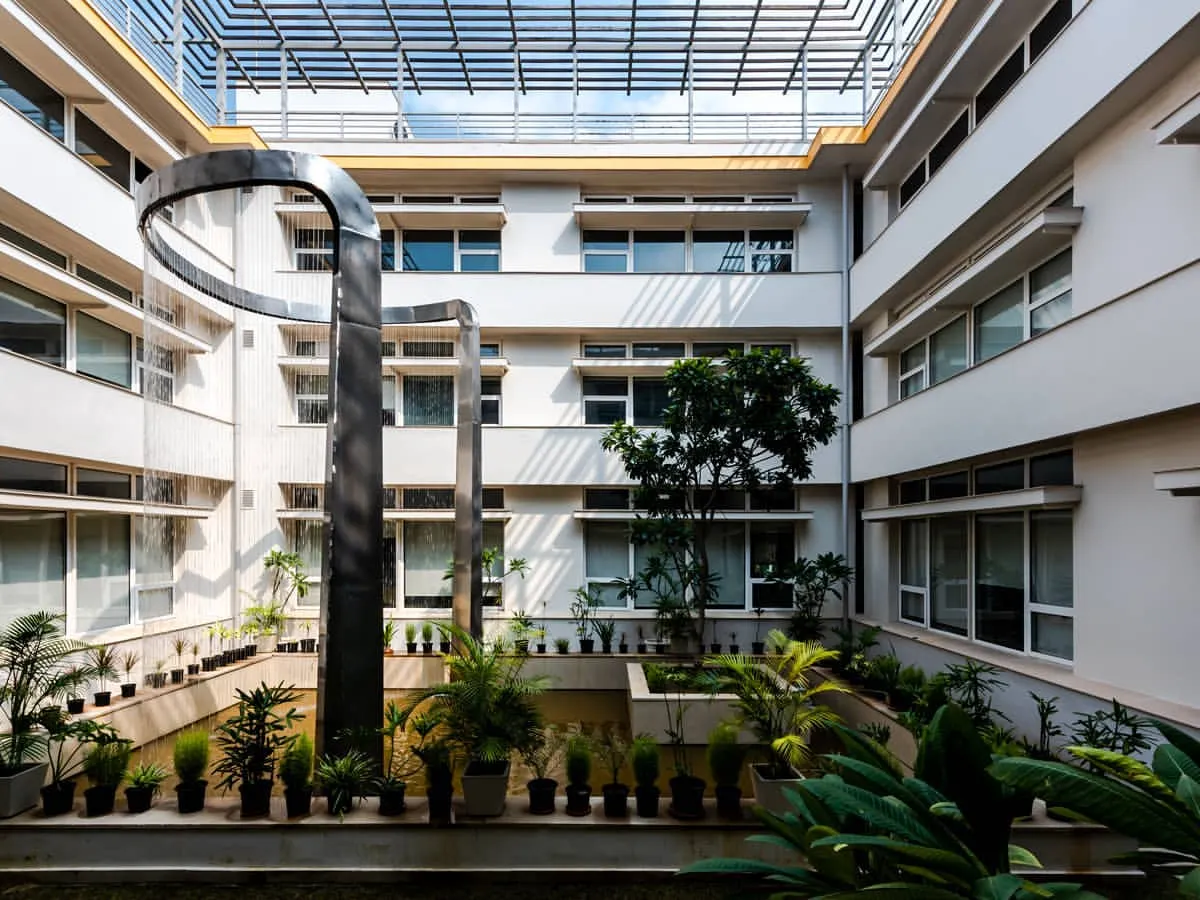 The central courtyard of our LEED Platinum certified office in Noida. The space is designed around a water body that acts as a natural heat sink, passively cooling the building and creating a tranquil heart for the workplace. This is how we build spaces that breathe.