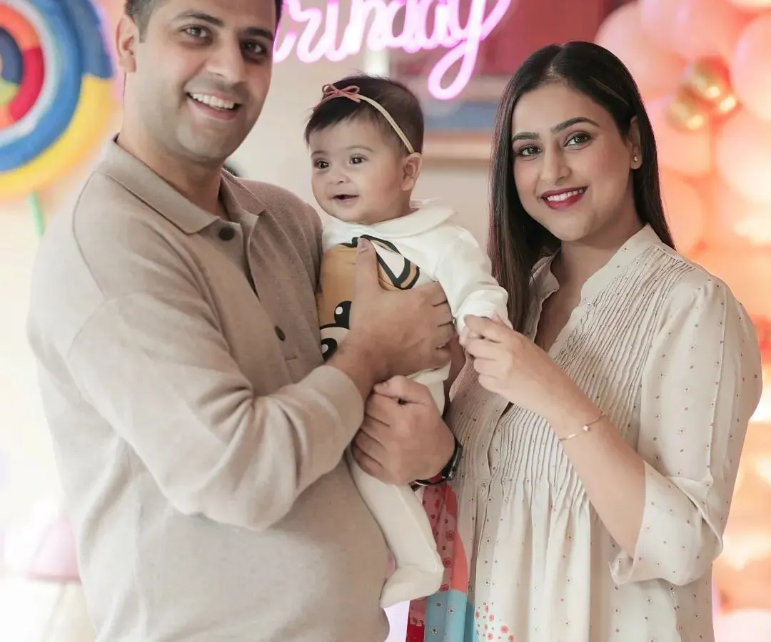 A happy family portrait at a baby's half birthday party. I focus on capturing the joy of these milestones, complete with festive decorations like balloons and neon signs that make the day special.
