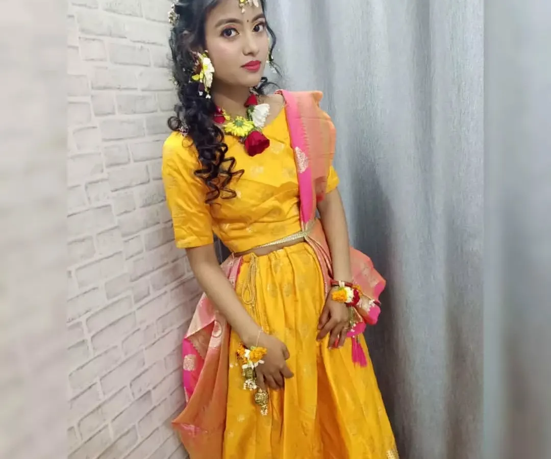 We teach our students specialized event makeup, including this complete Haldi look. This student's work features vibrant eye makeup, soft hairstyling, and the art of creating and placing fresh flower jewelry, a skill highly in demand for pre-wedding functions.