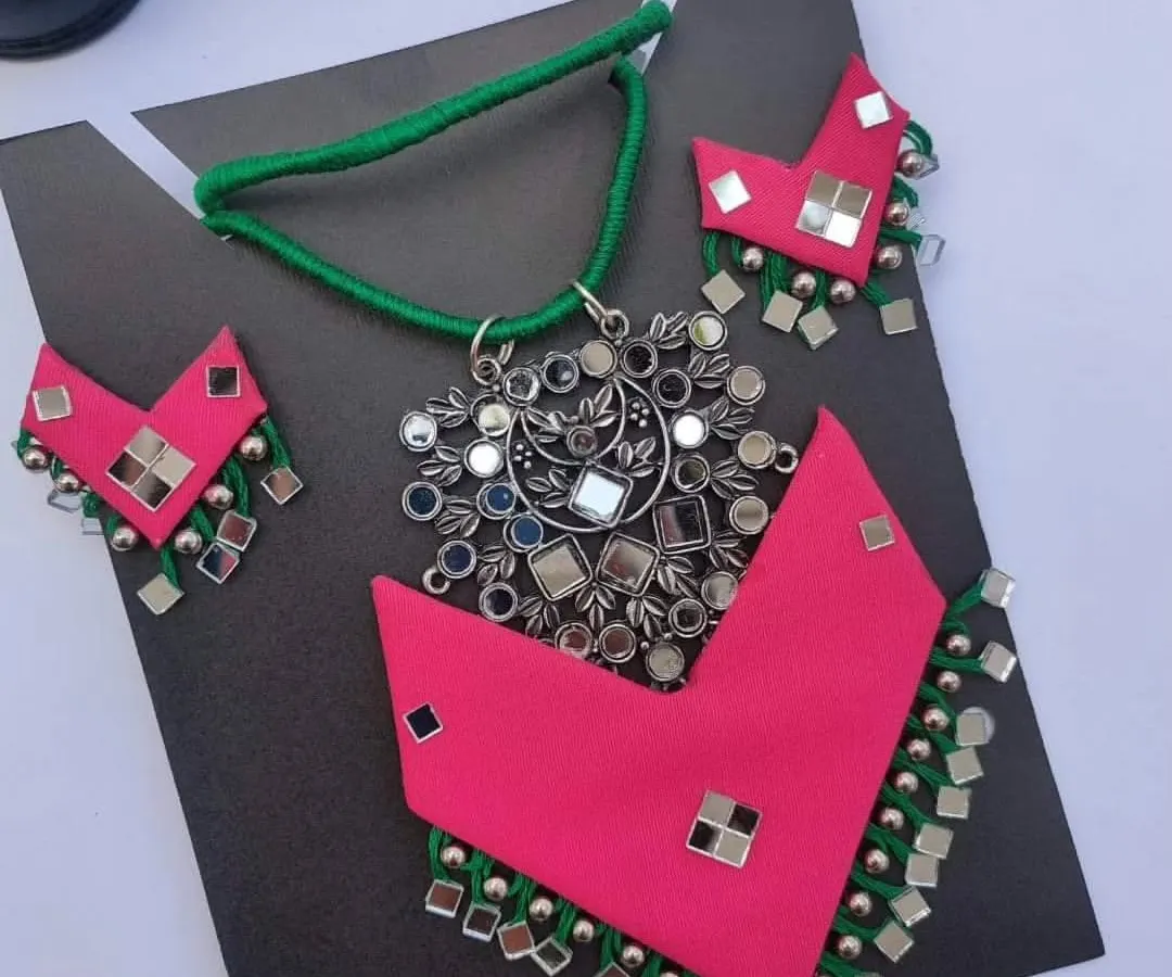 I love working with bright colours, and this pink and green fabric necklace set is a perfect example. It features a large mirror work pendant and matching earrings with ghungroos, making it a true statement piece for any celebration.