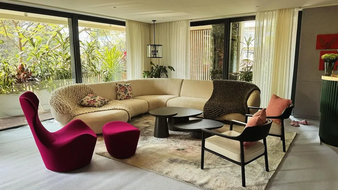 We designed this living space around a custom curved sofa that encourages conversation, complemented by a sculptural magenta lounge chair. The furniture works together to create a room that is open, connected to the outdoors, and full of personality.