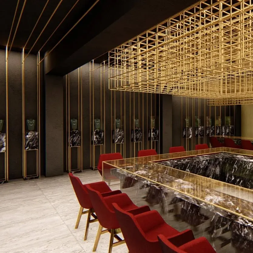 A view into a high-end jewelry showroom in Lucknow, designed to feel like a precious box. We used a suspended brass mesh structure to define the space and act as a lighting fixture, creating a dramatic contrast with the dark, coarse walls and polished marble counters.