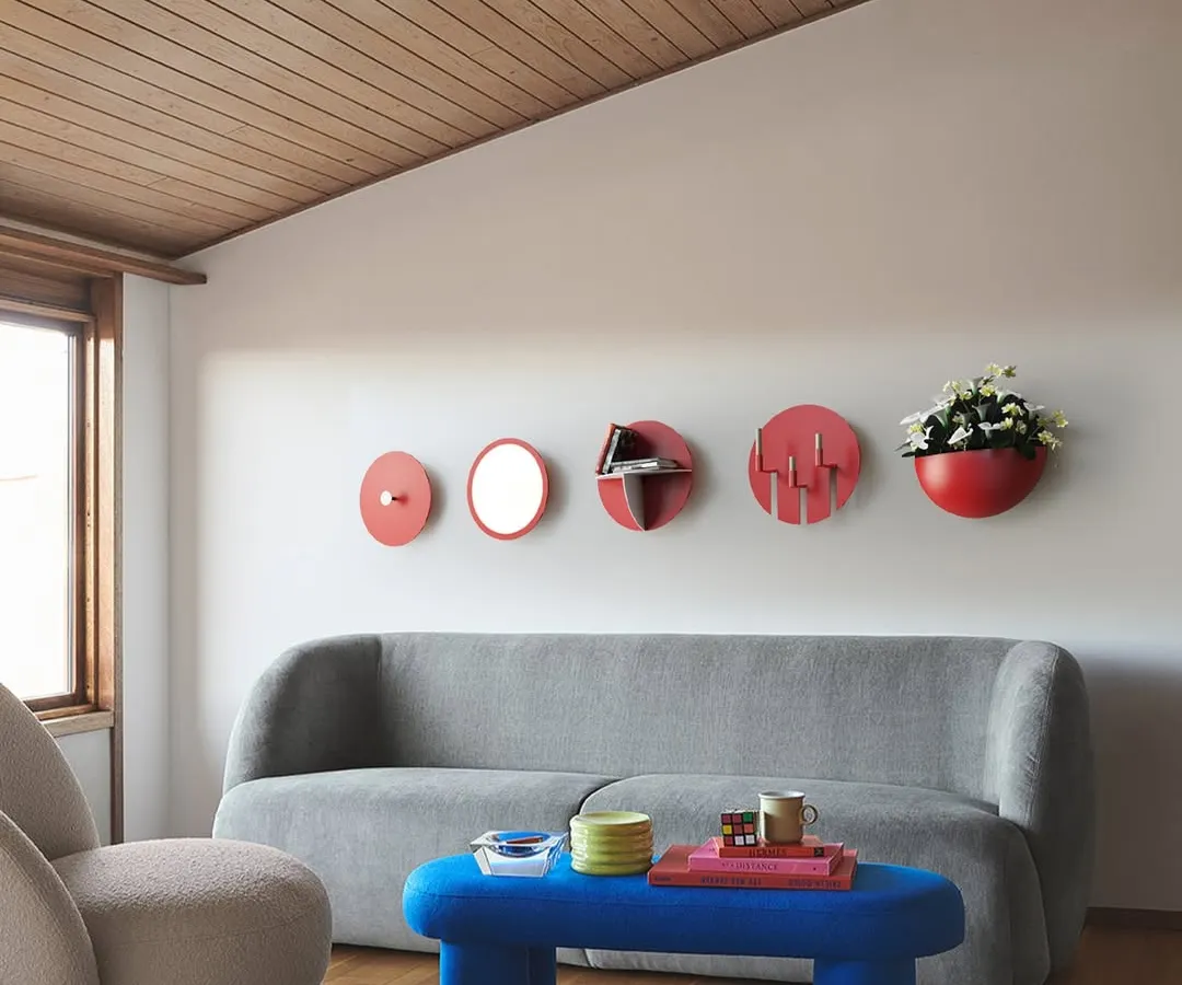 Our Aabhla collection reimagines the traditional Lipan Kaam craft of Kutch for modern interiors. This wall display features a composition of circular mirrors, shelves, and planters, adding a vibrant, culturally rich focal point to a contemporary living space.