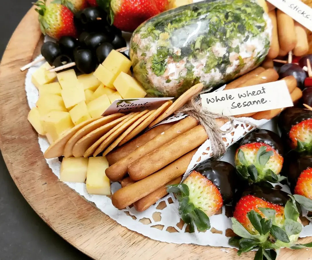 Our gourmet cheese platter is perfect for any special occasion, featuring our homemade herb-crusted cheese log, assorted cheese cubes, fresh strawberries dipped in chocolate, and a variety of crackers.