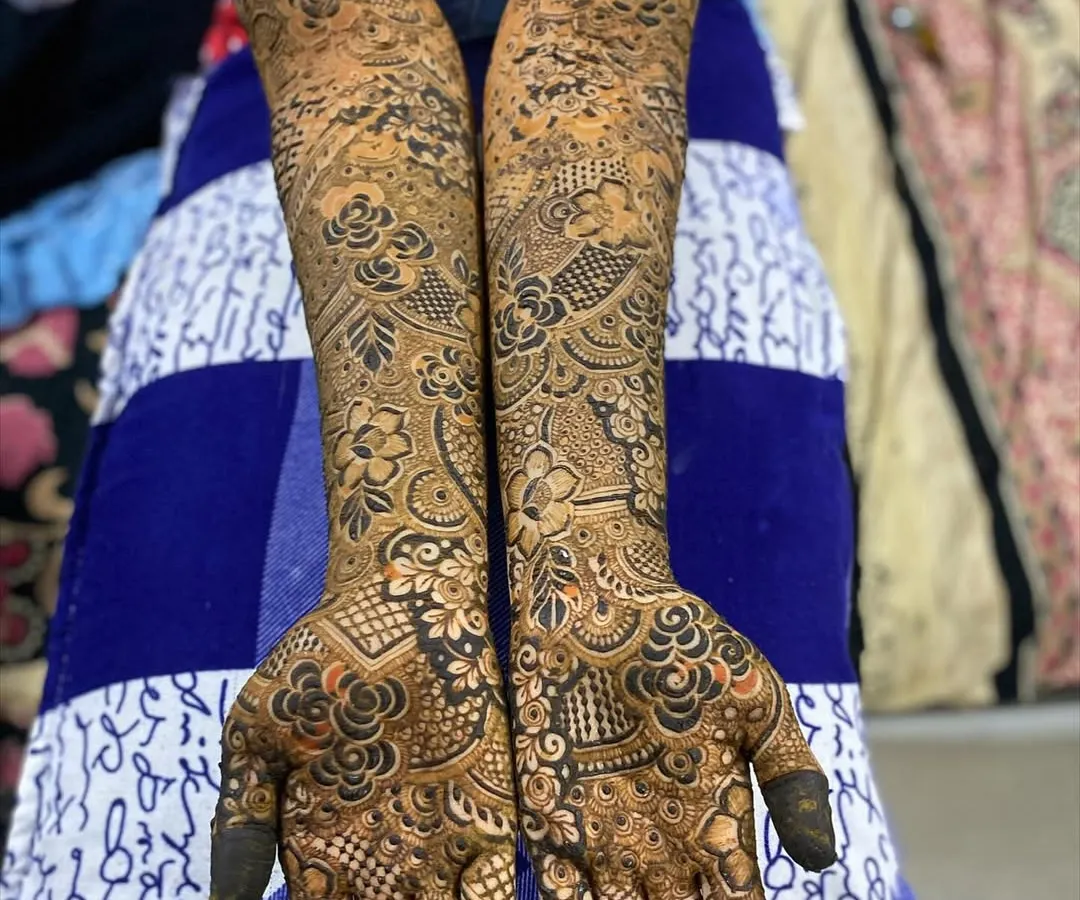 A perfect example of my full-coverage bridal henna. I meticulously layer intricate patterns, including floral work and delicate netting, to create a design that extends from the palm to the elbow, ensuring you look stunning from every angle.