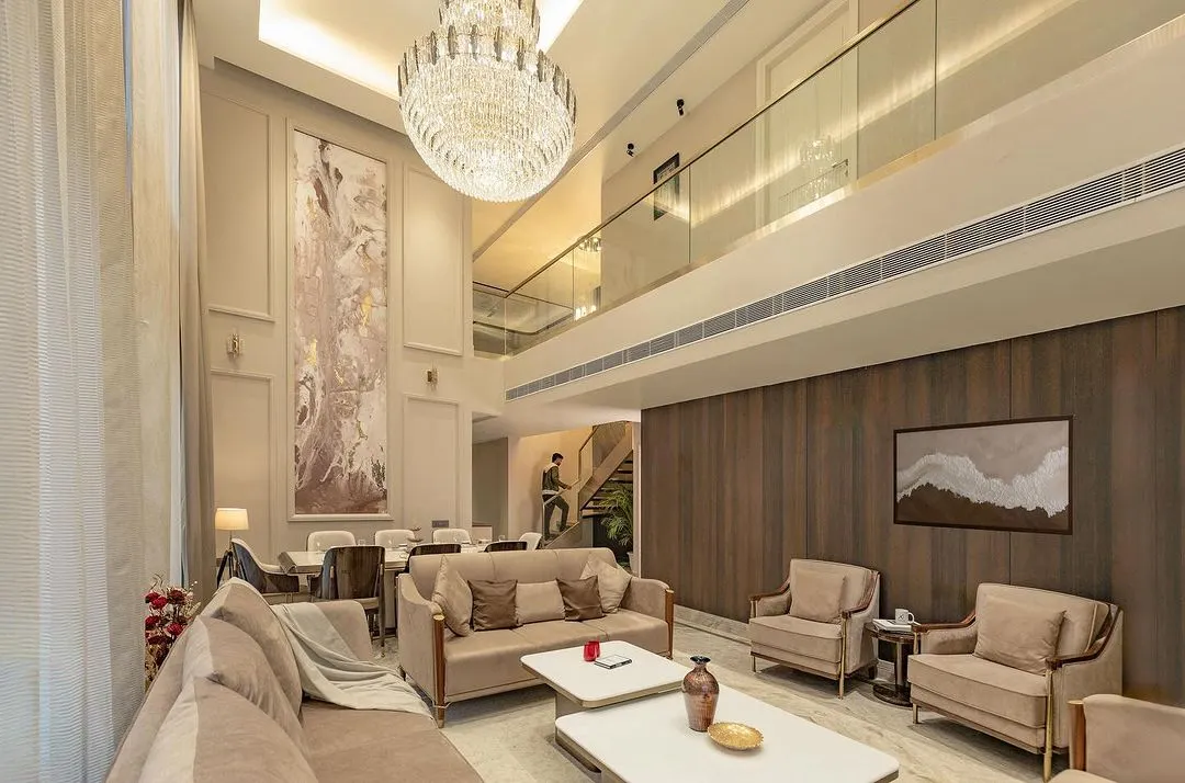 We believe in creating spaces with presence. This double-height drawing room uses vertical volume, a statement chandelier, and a neutral palette to create an atmosphere of classical opulence and refined comfort.