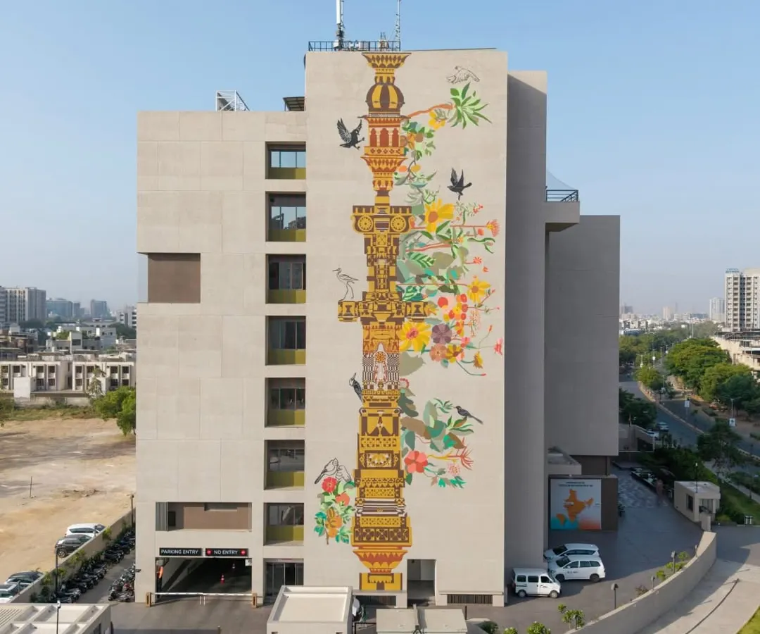Our work often becomes a landmark for the city itself. This multi-story mural, 'The Tower of Harmony,' wraps the HCG Multispeciality Hospital in Ahmedabad, serving as a tribute to the city's heritage and ecological balance. We designed this vertical pillar as a symbolic 'stambh' or tower of values, blending traditional Indian temple architecture with contemporary aesthetics to create public art that inspires.