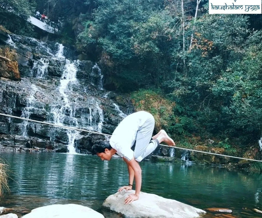 Here, I practice Bakasana, the Crane Pose, on a rock amidst a flowing waterfall. This arm-balancing asana requires immense focus and core strength, teaching us to find stillness and stability even when surrounded by constant movement. Through my guidance, you will learn to build such physical and mental fortitude, one breath at a time.