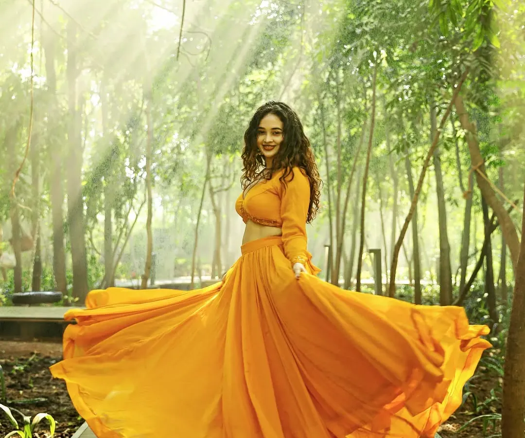 A full-length fashion shot of a model in a flowing orange lehenga, captured outdoors with beautiful natural light rays. This image demonstrates my ability to create dynamic, eye-catching visuals for ethnic wear and designer apparel brands.