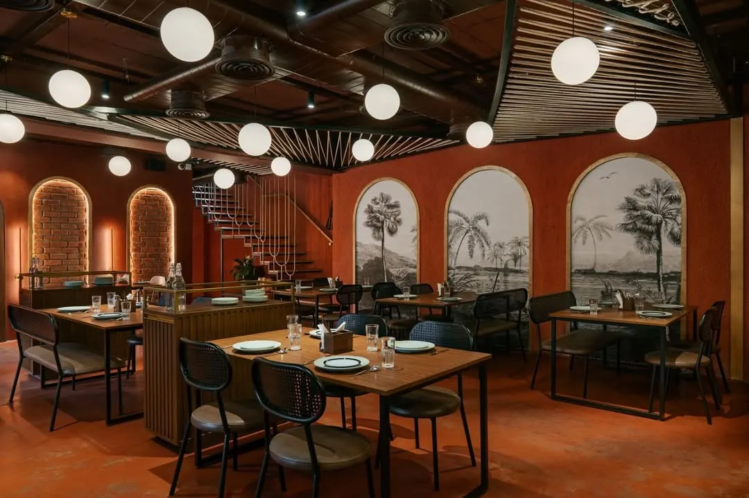 For the 'Chambal' restro-bar, I used a monochromatic palette of rustic red and exposed brick to create a warm, immersive dining experience. The design, including the globe pendant lights, evokes a sense of rustic celebration while maintaining a modern, open-plan layout.
