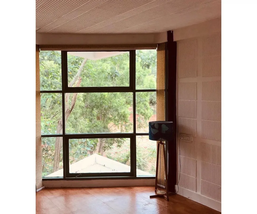 In this farmhouse retreat, a large window frames the lush greenery outside, turning nature into living art. My focus here was on biophilic design, creating a seamless connection between the interior and the exterior for a truly peaceful weekend home.