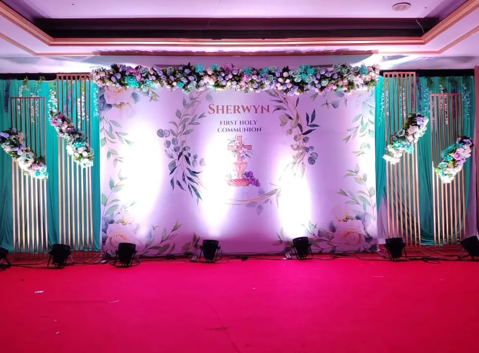 A clean and elegant stage for Sherwyn's First Holy Communion. The setup features a personalized backdrop with his name, beautiful floral arrangements, and professional lighting to make the moment feel truly special and blessed.