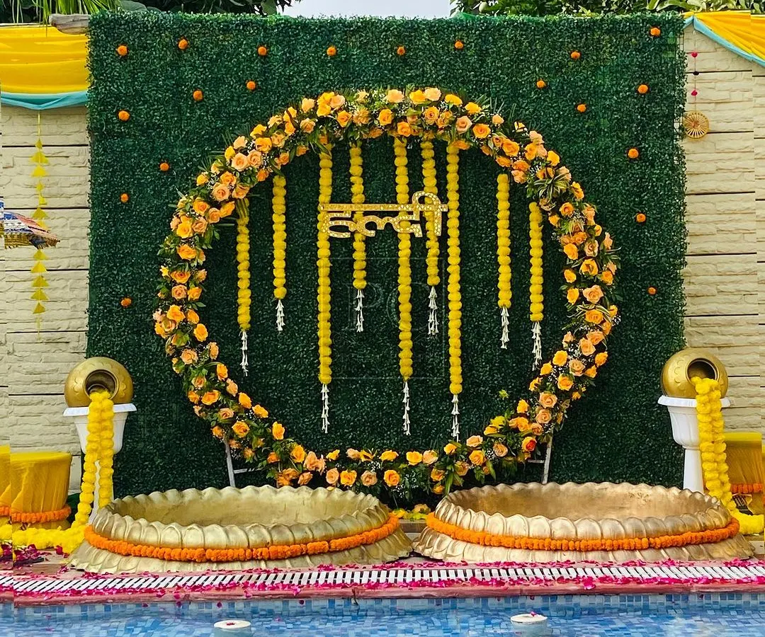 I love creating stunning poolside Haldi setups. For this event, I designed a circular marigold floral backdrop against a lush green wall, complete with traditional brass urlis, making it a perfect blend of modern and classic Haldi decor.