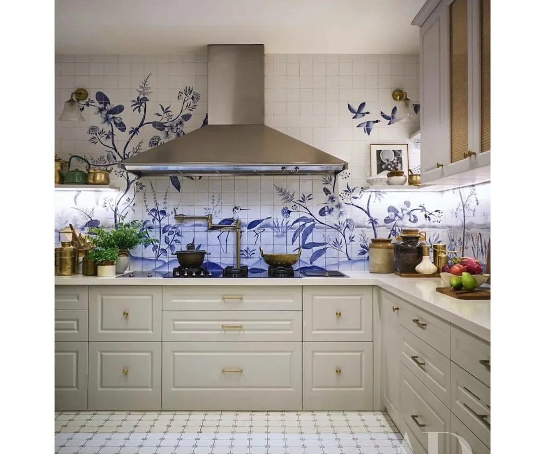 This kitchen, featured in Architectural Digest, is one of my favorites. We used custom hand-painted tiles to create a beautiful, classic blue and white floral design, blending it with modern shaker cabinets and a stainless steel chimney for a timeless look.