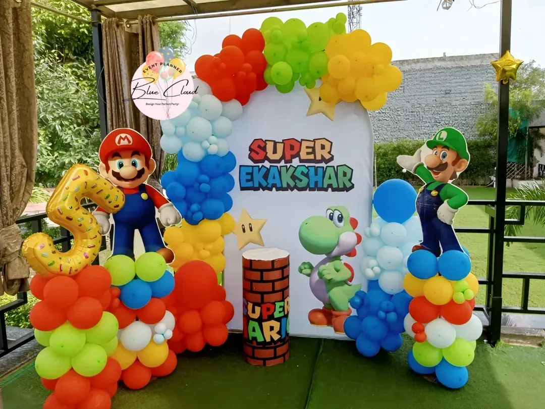 Bringing the game to life with a Super Mario themed birthday party. This outdoor setup includes character cutouts of Mario and Luigi, a custom backdrop, and vibrant balloon columns.