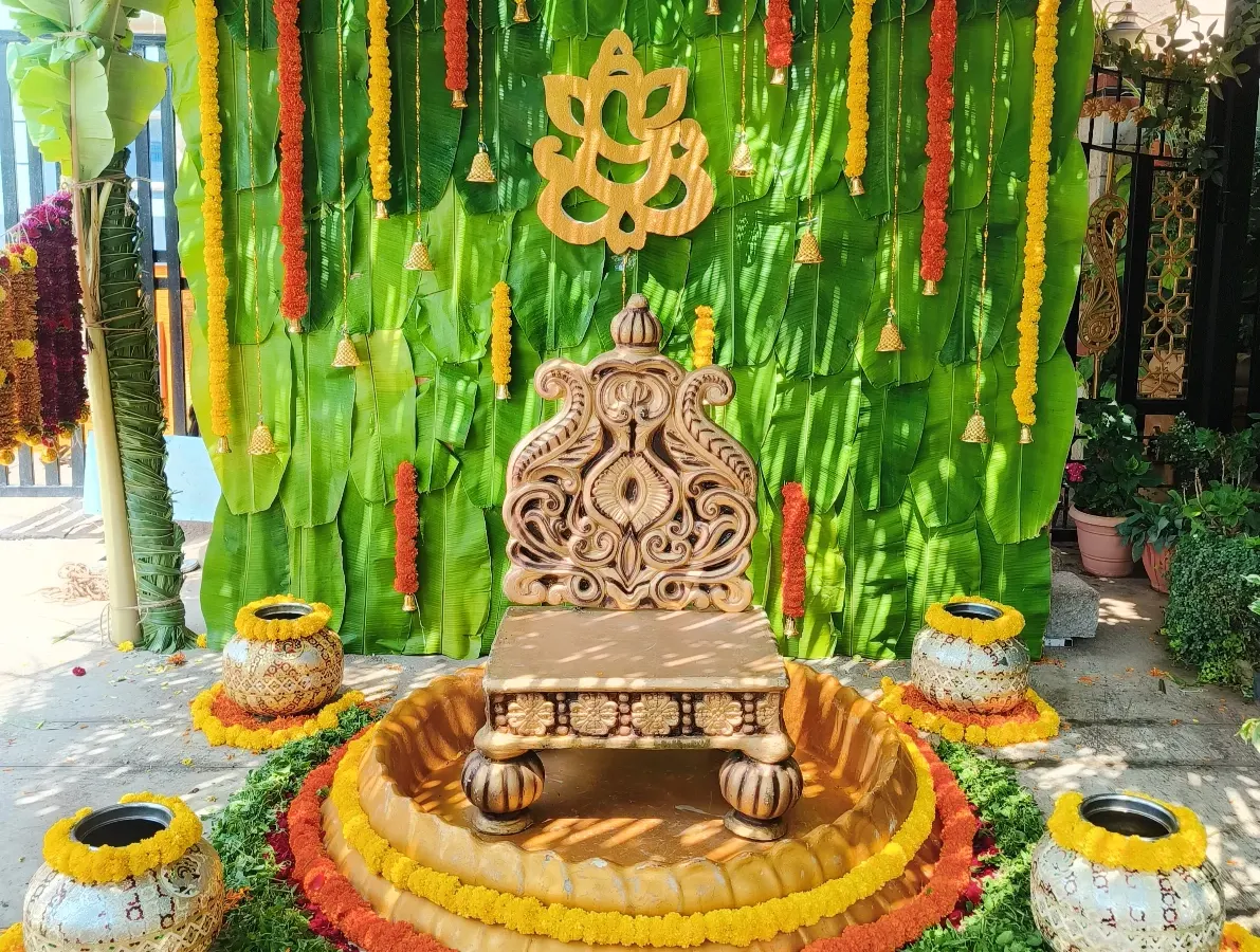 This is a beautiful example of my traditional decor, perfect for a naming ceremony or Seemantham. The backdrop is made of fresh banana leaves, adorned with marigold garlands and a central Ganesha motif, with an ornate seat ready for the ceremony.