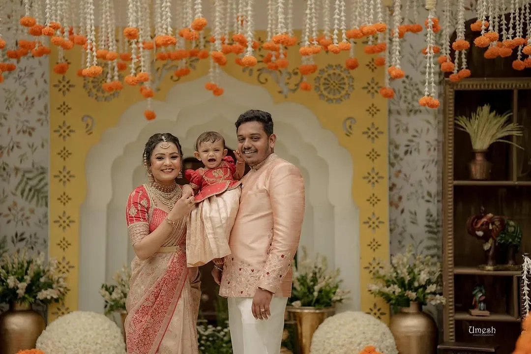 There is nothing more special than dressing the entire family. Here, we created a coordinated set in peach and red for a naming ceremony, ensuring the parents and their little one looked picture-perfect for their milestone celebration.