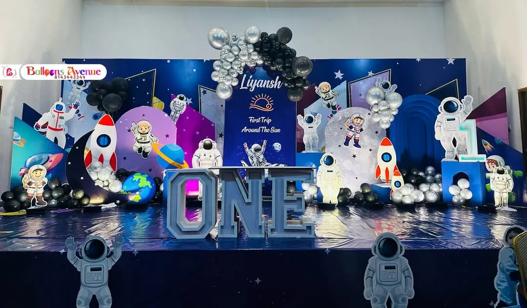 An out-of-this-world space theme for a first birthday party. I designed this entire stage with astronaut cutouts, rocket ships, planet props, and a floor that looks like the galaxy.