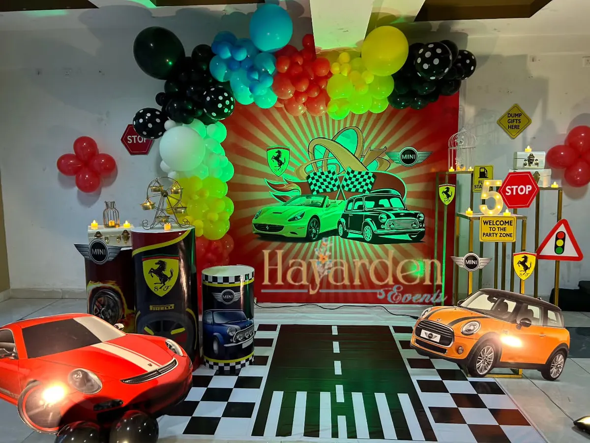 For the little car enthusiast, I designed this complete race car themed party. The setup includes a custom printed backdrop, themed plinths, car cutouts, and even a floor decal that looks like a road. It’s an immersive experience for a high-energy birthday.