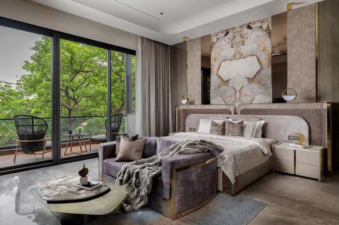 This master bedroom was designed as a quiet getaway within the home. We connected it to the outdoors with large sliding doors and used a palette of warm tones, soft textures, and a statement marble headboard to make the indoors feel calm and indulgent.