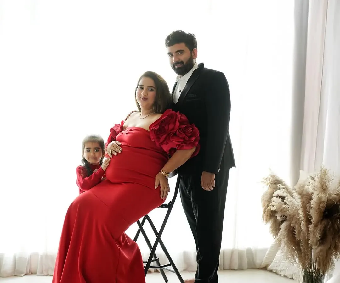 A formal studio portrait celebrating the next chapter. This maternity session captures the elegance and excitement of a growing family, with coordinated outfits creating a classic, polished look.