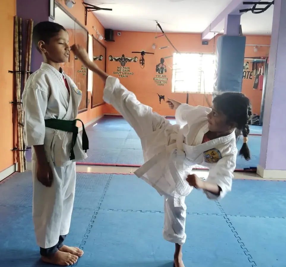 We believe in starting early. Here, one of our young students practices a high kick, building not just physical skill but also the discipline and confidence that are the foundations of martial arts.
