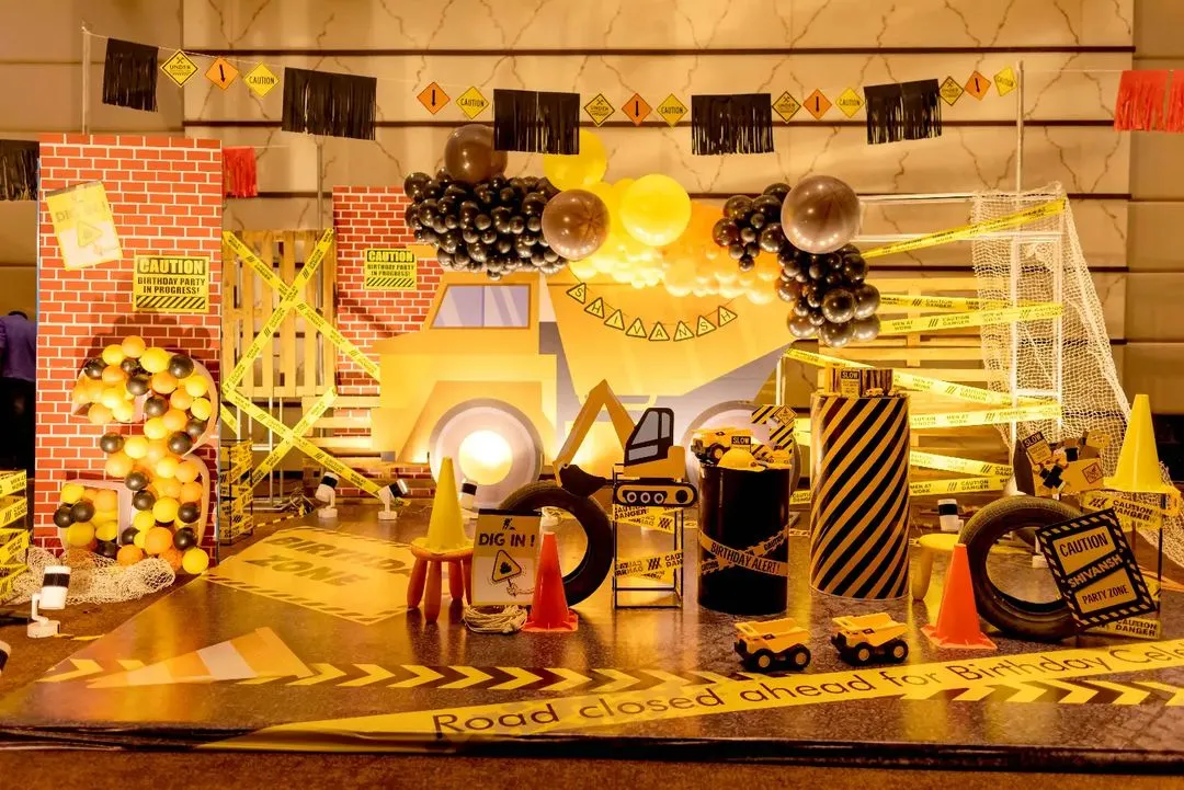 For the little builder in your life, I design action-packed construction zones. This setup features a full-scale backdrop with a dump truck, caution tape, traffic cones, and custom signage, turning the party space into a fun and interactive work site.