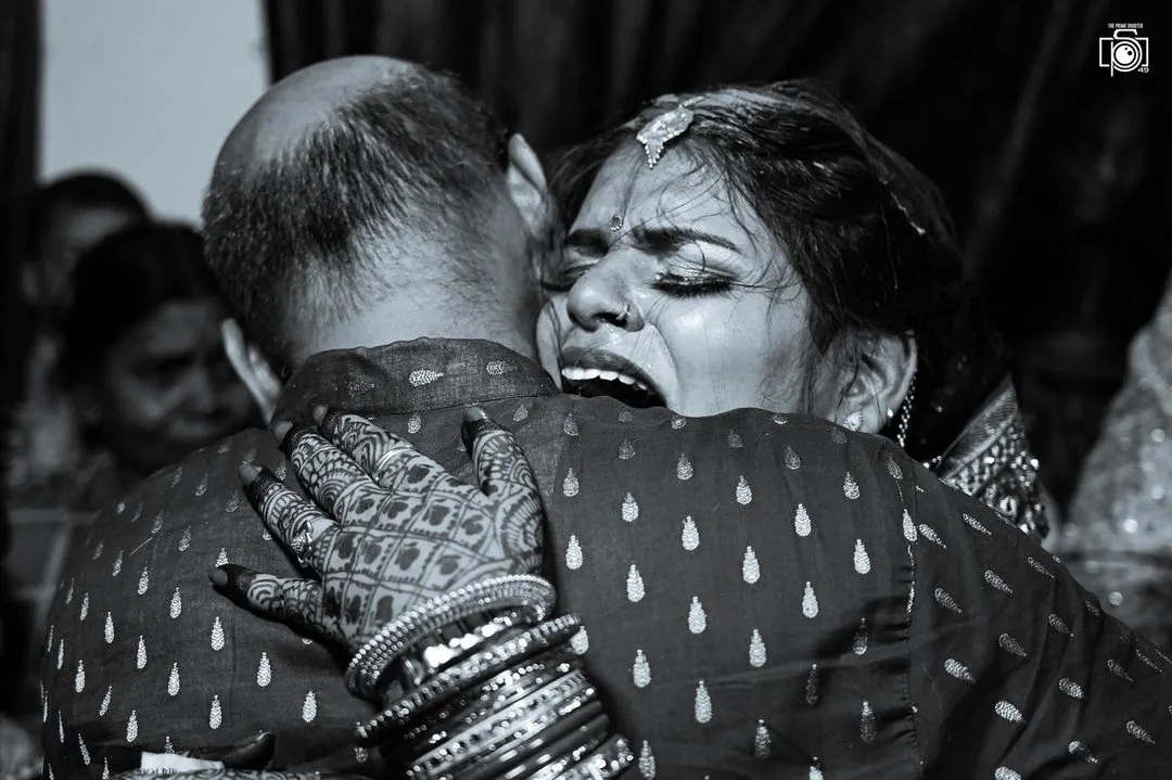 The vidaai is one of the most emotional moments in an Indian wedding. I focus on capturing the real, unfiltered feelings, like this powerful embrace between a bride and her father. This black and white photo highlights the intensity of the moment, creating a memory that will last forever.