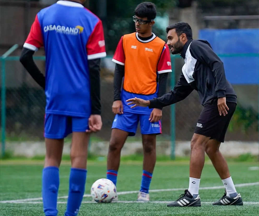 Our certified coaches provide personalized guidance to every player. Here, a coach offers tactical advice during a training drill, focusing on positioning and game awareness to help our young athletes think like pros.