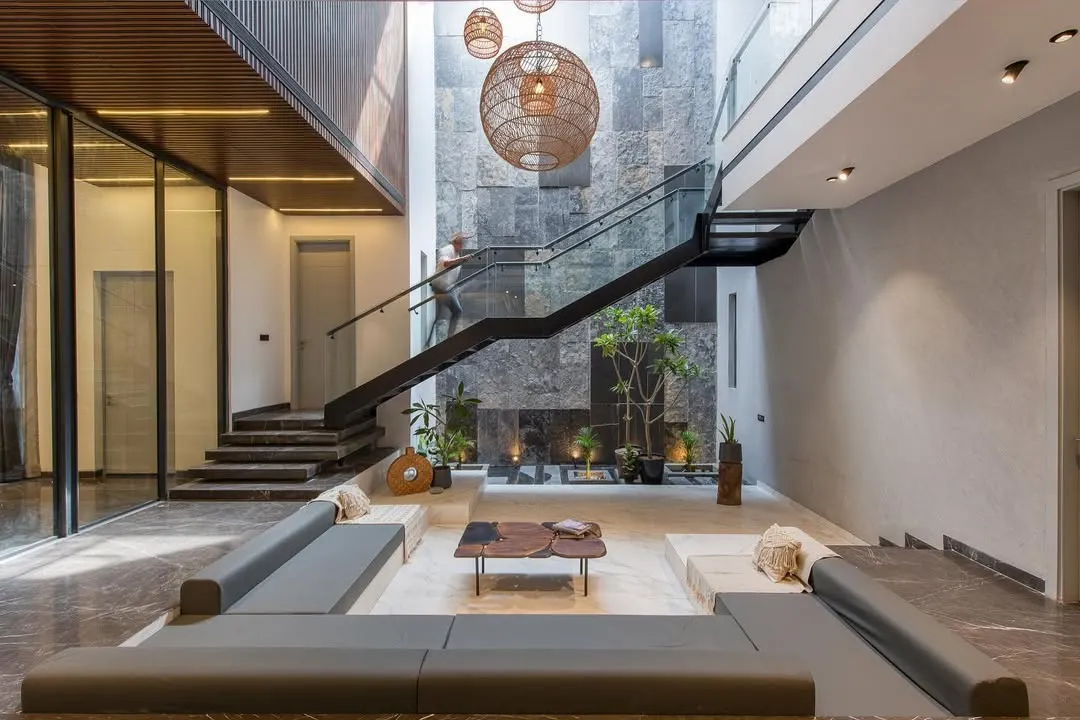 Inside the Casa Acentuada project, I designed this sunken lounge to be a tranquil heart of the home. The double-height space is anchored by a natural stone wall and a floating staircase, creating a dramatic interplay of light, volume, and texture.