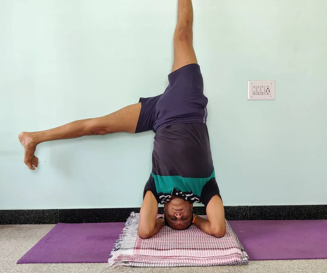 Here I am demonstrating a variation of Shirshasana (Headstand), using the wall for balance and alignment. This is Parsvaika Pada Shirshasana. The wall is a tool, a teacher. It provides feedback so you can understand the correct extension and rotation in the pose without fear of falling.