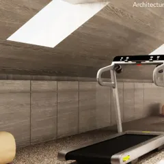 An attic gym space, showing how we can transform unconventional areas into highly functional rooms. The sloped ceiling and skylights create a unique atmosphere for a workout.