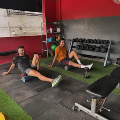 Recovery is a team sport too. Two members use foam rollers to release muscle tension after a tough workout. We teach our clients the importance of self-myofascial release for injury prevention.
