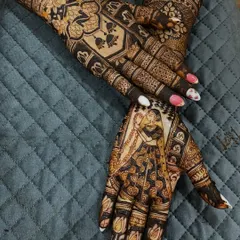 Capturing the pinnacle of the wedding ceremony, the Varmala. This design features a portrait of the bride and groom exchanging garlands, a moment of union and celebration immortalized in henna.