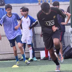 Young footballers participating in agility and speed drills using cone markers. These technical assessments are a crucial part of the selection process during the youth league trials I manage.
