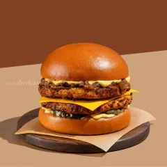 A perfectly stacked double-decker burger with melted cheese and fresh toppings, captured with clean, bright lighting to emphasize its juicy, appetizing details.