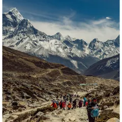 A team of trekkers making their way along the classic EBC trail. The path winds through the Khumbu valley, with the majestic peak of Ama Dablam and other Himalayan giants watching over the journey.