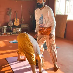 I believe in guiding each student personally. Here, I am offering a gentle adjustment in a forward fold, helping the student to find space and release tension safely. My approach is to meet you where you are, with patience and support, so you can trust your body and deepen your practice without force.