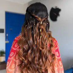 A beautiful half-up hairstyle with intricate braids and soft waves. I added delicate gold beads to the braids for a touch of bohemian elegance, perfect for a Roka or Mehendi ceremony.