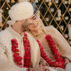 A joyful, candid moment of the couple sharing a laugh during their intimate wedding, surrounded by the warmth of their loved ones.