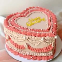 A beautiful heart-shaped cake with ombre pink Lambeth piping. The layers of detailed piping create a stunning, textured effect perfect for a romantic celebration.