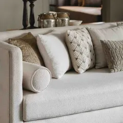 We love layering textures. Here, a variety of cushions in neutral tones with different weaves and patterns adds depth and comfort to a simple, elegant sofa.
