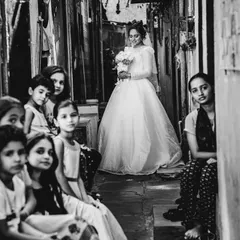 A powerful black and white portrait of the bride in a narrow alley, with local children looking on. This image tells a rich, authentic story.