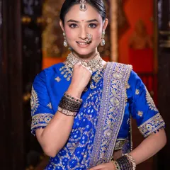 The quintessential Maharashtrian bride pose. Her makeup is kept clean and radiant, drawing attention to the beautiful traditional jewelry and her bright, happy expression.