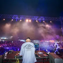 Another angle of me controlling the vibe for a huge festival crowd. The stage setup, smoke, and lights all add to the epic atmosphere of a headline performance.