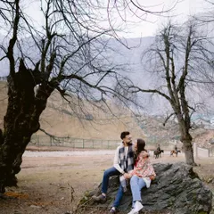 Framed by the stark, beautiful trees of a Kashmiri winter, they share a look. The world around them is quiet, making their connection the focal point of the entire scene.