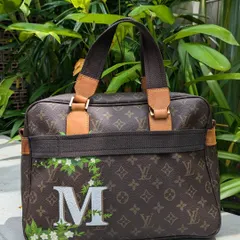 The customization continues on the back. I painted a large initial 'M' in a classic font, with the floral vine design wrapping around it to make the bag truly personal for the client.