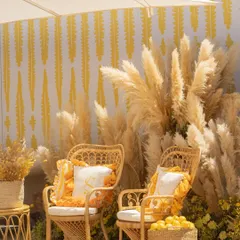 For this Mehendi in Cannes, I created a chic, sun-drenched photo corner with rattan chairs, custom monogrammed cushions, and a backdrop of pampas grass.
