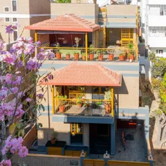An aerial view of the Audumbara residence, highlighting its distinctive terracotta roofs and lush green balconies. The architecture is designed to blend seamlessly with the surrounding landscape, even in an urban setting.