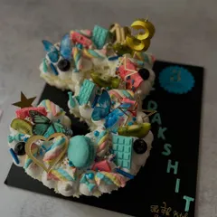 This number 3 cake has a whimsical, fairy-garden feel. It's decorated with pastel buttercream, edible butterflies, macarons, marshmallows, and fresh kiwi slices for a light and colorful celebration cake.